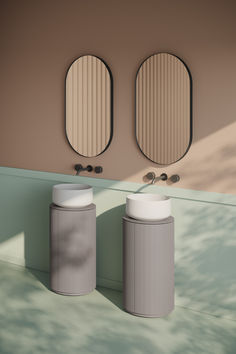 two round mirrors are on the wall next to each other in front of a sink