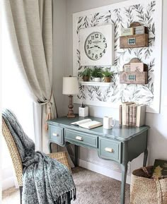 a desk with a clock on the wall above it and some baskets under it next to a window