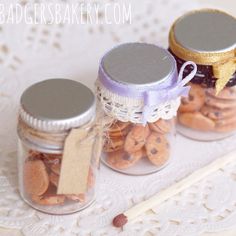 three jars filled with cookies on top of a doily