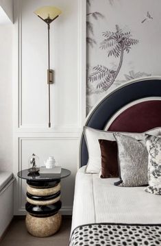 a bedroom with a bed, side table and wallpaper