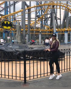 a woman standing in front of a batmobile ride