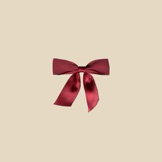 a red bow on top of a beige wall with no one in the room behind it