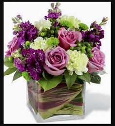 a vase filled with purple and white flowers