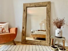 a mirror sitting on top of a wooden floor next to a chair