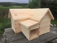 a wooden bird house sitting on top of a wooden platform