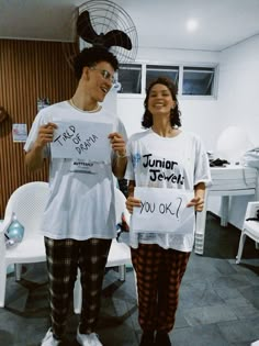 two people standing next to each other holding signs