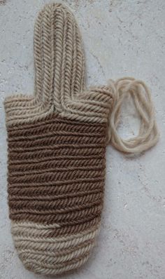 a brown and white knitted bag on the ground