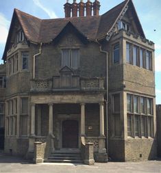 an old building with pillars and windows on the top floor, in front of a blue sky