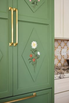 a green cabinet with flowers painted on the front and side panels, in a kitchen