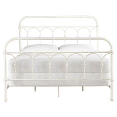 a white metal bed frame with two pillows