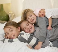 three children laying on top of each other on a bed with the caption oh a happy day