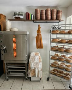 an industrial bakery with breads and pastries on racks in front of the oven