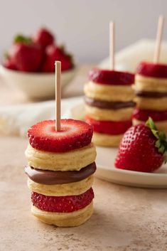 strawberry shortcakes stacked on top of each other with strawberries in the background