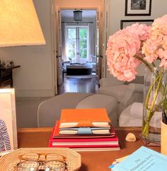 a living room filled with lots of furniture and flowers in vases on top of a table