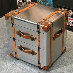 a silver and brown suitcase sitting on top of a gray counter next to other items