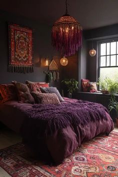 a bed with purple comforter and pillows in a dark room next to a window