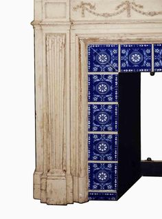 an old fireplace with blue and white tiles on it