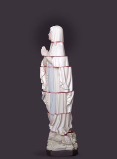 the statue is white and has red lines on its sides as it stands in front of a black background