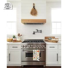 a stove top oven sitting inside of a kitchen next to white cabinets and counter tops