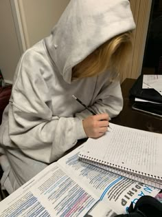 a person sitting at a desk writing on paper