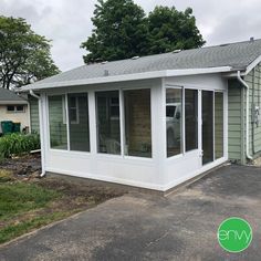 a small white building sitting in the middle of a yard