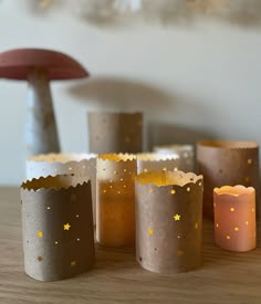 some paper cups with gold stars on them sitting on a table next to a mushroom