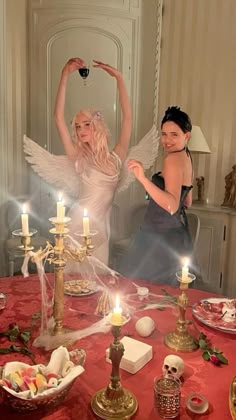 two women standing around a table with candles