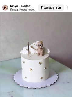 there is a small white cake with stars and a teddy bear in the top one