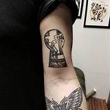 a person with a tattoo on their arm holding a cell phone and a keyhole