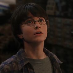 a young boy wearing glasses looking up at something