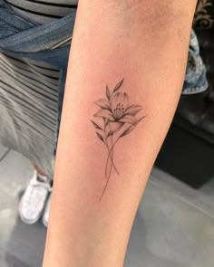 a woman's arm with a flower tattoo on it