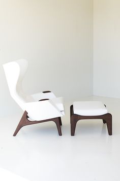 two white chairs sitting next to each other on top of a white floored room