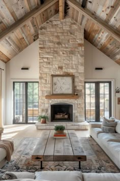 a living room with couches and a fireplace in the center, surrounded by wooden beams