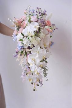 a woman holding a bouquet of flowers in her hand