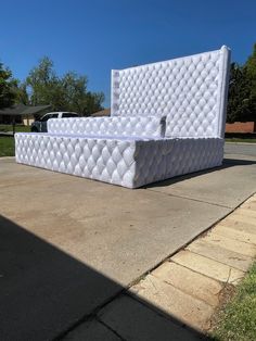 a white mattress sitting on top of a sidewalk