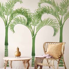 a living room with palm trees painted on the wall and coffee table in front of it