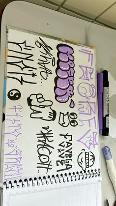 a white and purple sign with writing on it next to some pens, scissors and markers