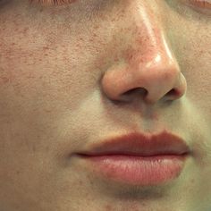 a woman's face with freckles on her cheeks and eyes close up