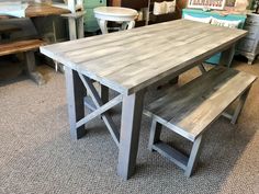 a wooden table with two benches next to each other in a room filled with furniture