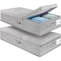 two gray storage boxes with folded towels inside