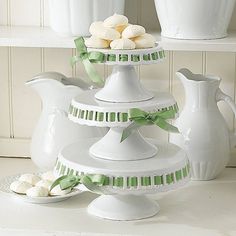 three tiered white dishes with green ribbons on the top and one holding marshmallows