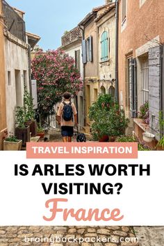 a person walking down an alley way with text overlay that reads travel inspiration is arles worth visiting france