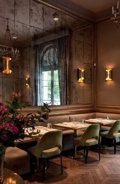 a restaurant with tables, chairs and chandeliers in the middle of the room