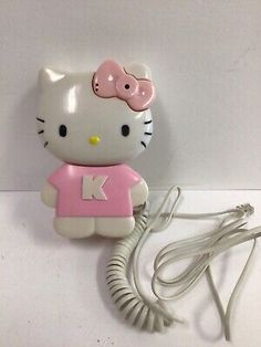 a hello kitty phone with a pink shirt on it's charger and cord