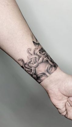 a person's arm with a tattoo on it and a hand holding the wrist