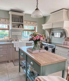 a kitchen with an island in the middle of it and lots of flowers on top