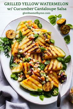 grilled yellow watermelon salad with cucumber and mango salsa on a white plate