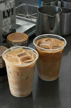 two iced drinks sitting on top of a counter