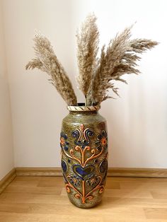 there is a vase with feathers in it on the floor