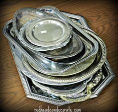 a stack of silver plates sitting on top of a wooden table